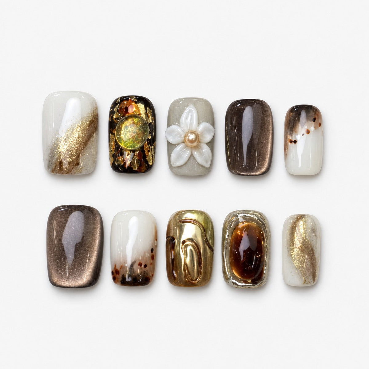 catalog: Short square press-on nails in glossy brown cat-eye and milky white shades with gold foil streaks and one white sculpted flower with a pearl centre.