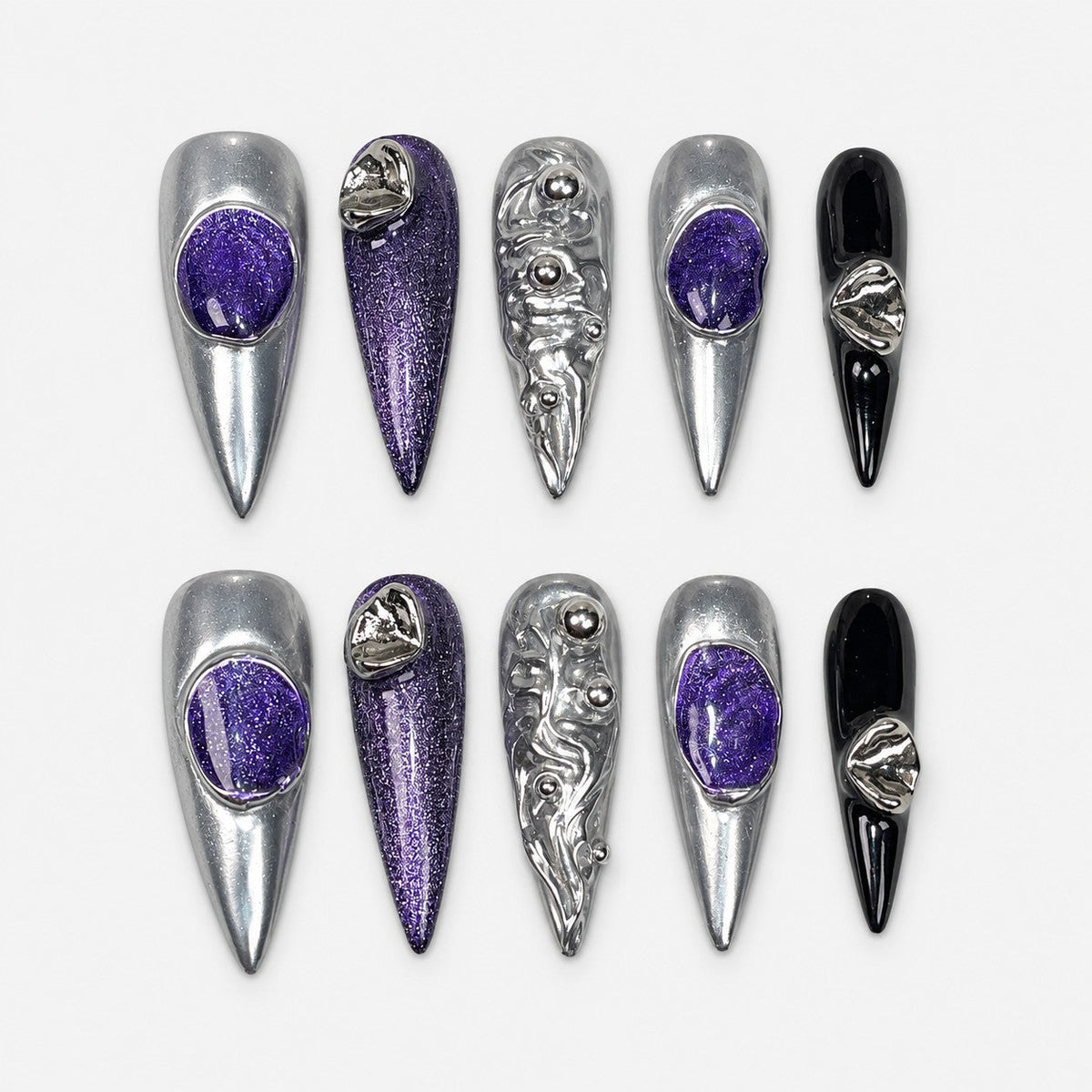 catalog: Long stiletto press-on nails in mirror silver chrome with deep purple glitter stones, sculpted silver ripples with metal beads, and two glossy black accent nails.
