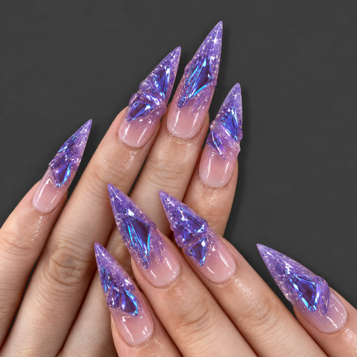 hand: Long stiletto press-on nails in translucent purple with sculpted glass-like shards flashing blue and violet.