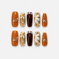 catalog: Long coffin press-on nails in amber, dark wine and sheer honey, with hand-painted white daisies, gold wire wrapping, pearls and crystals.