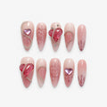 catalog: Long almond press-on nails with a milky nude to dusty rose gradient, raised glass hearts, painted heart outlines, silver chains and small crystals.
