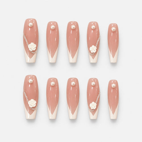 catalog: Long almond press-on nails with sheer blush base, soft white French tips, a sculpted white camellia flower, a silver chain and single pearls.