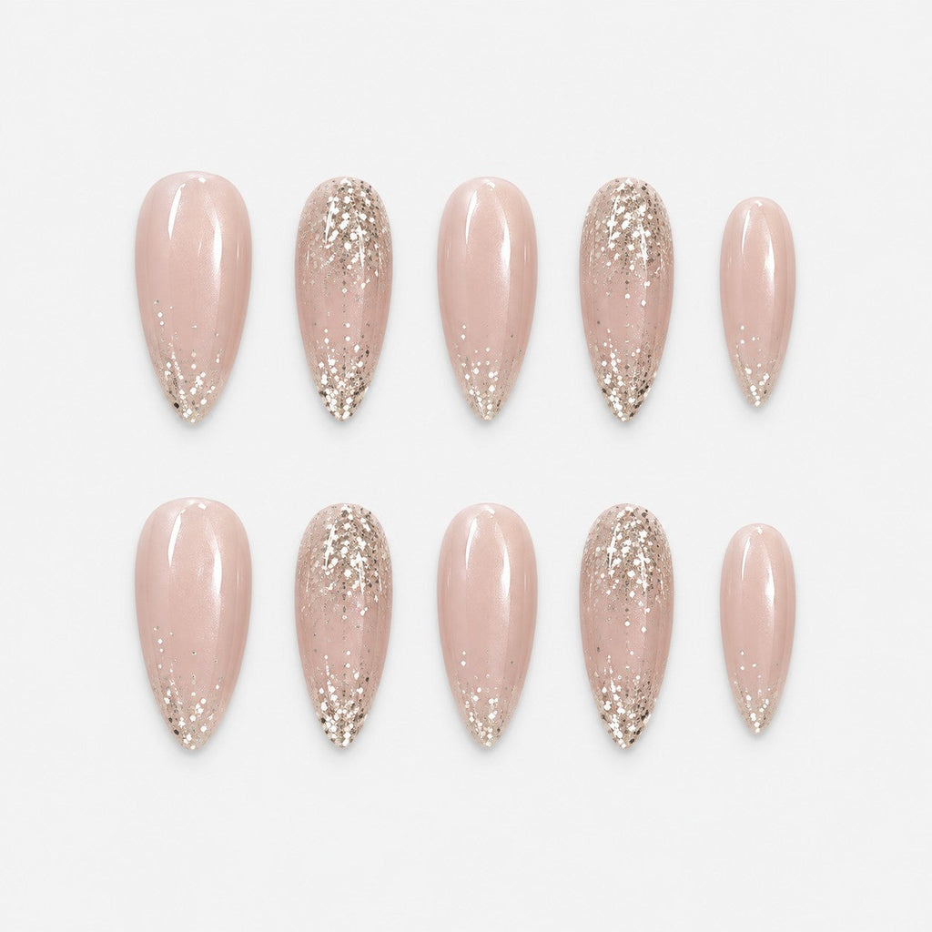 catalog: Long almond press-on set in sheer nude with pearly shimmer and champagne gold glitter tips.
