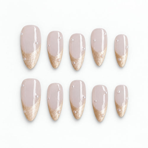 catalog: Medium almond press-on nails with a milky blush base, shimmering champagne French tips and small scattered pearls.