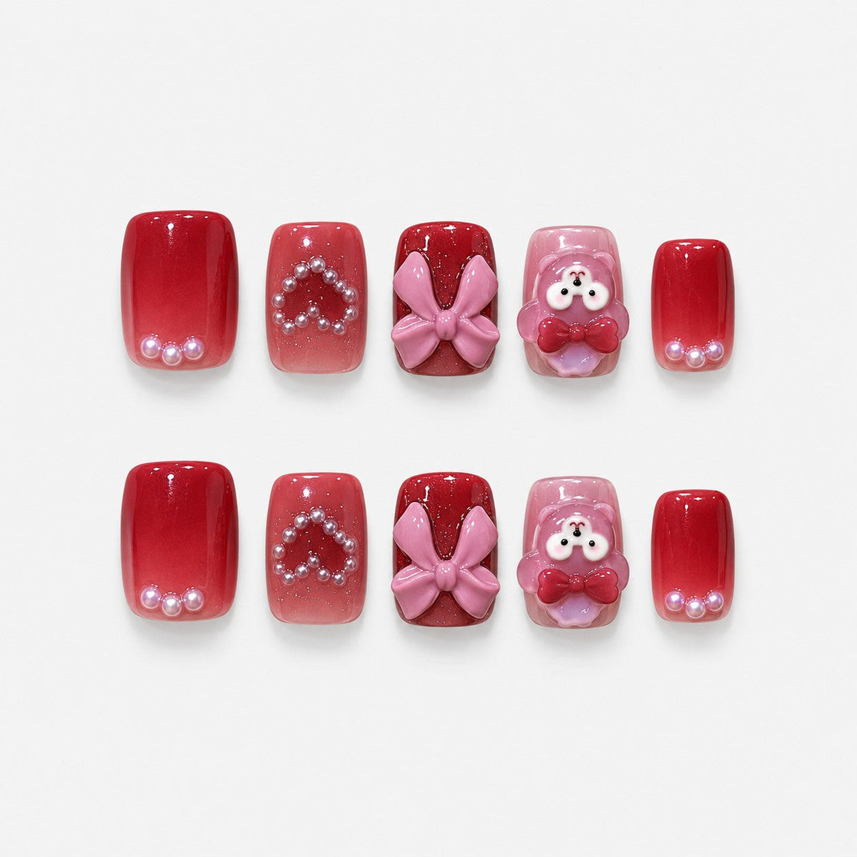 catalog: Medium square press-on nails in cherry red and mauve with a pink 3D bow, a bear charm and small pearl accents.