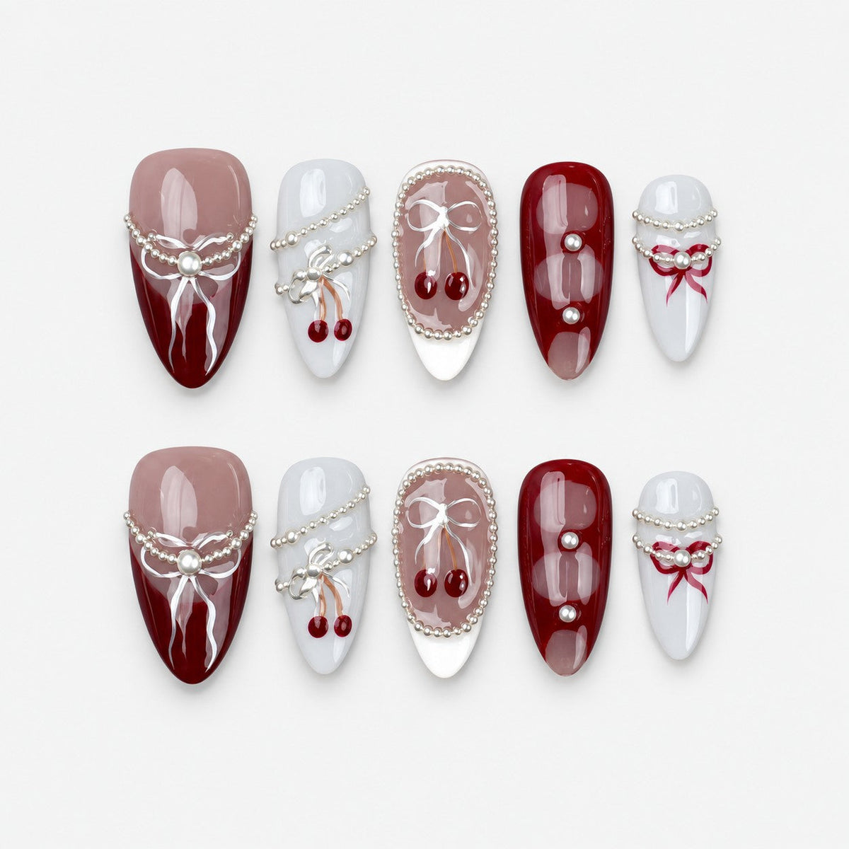 catalog: Medium almond press-on nails in burgundy, mauve and grey with painted white bows, silver bead strands and glossy red cherry charms.