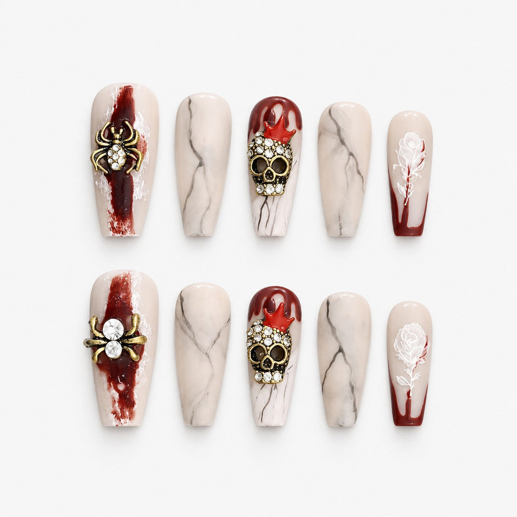 catalog: Long coffin press-on nails in nude and dark red with grey marbling, gold rhinestone spiders, jewelled skulls and painted white roses.