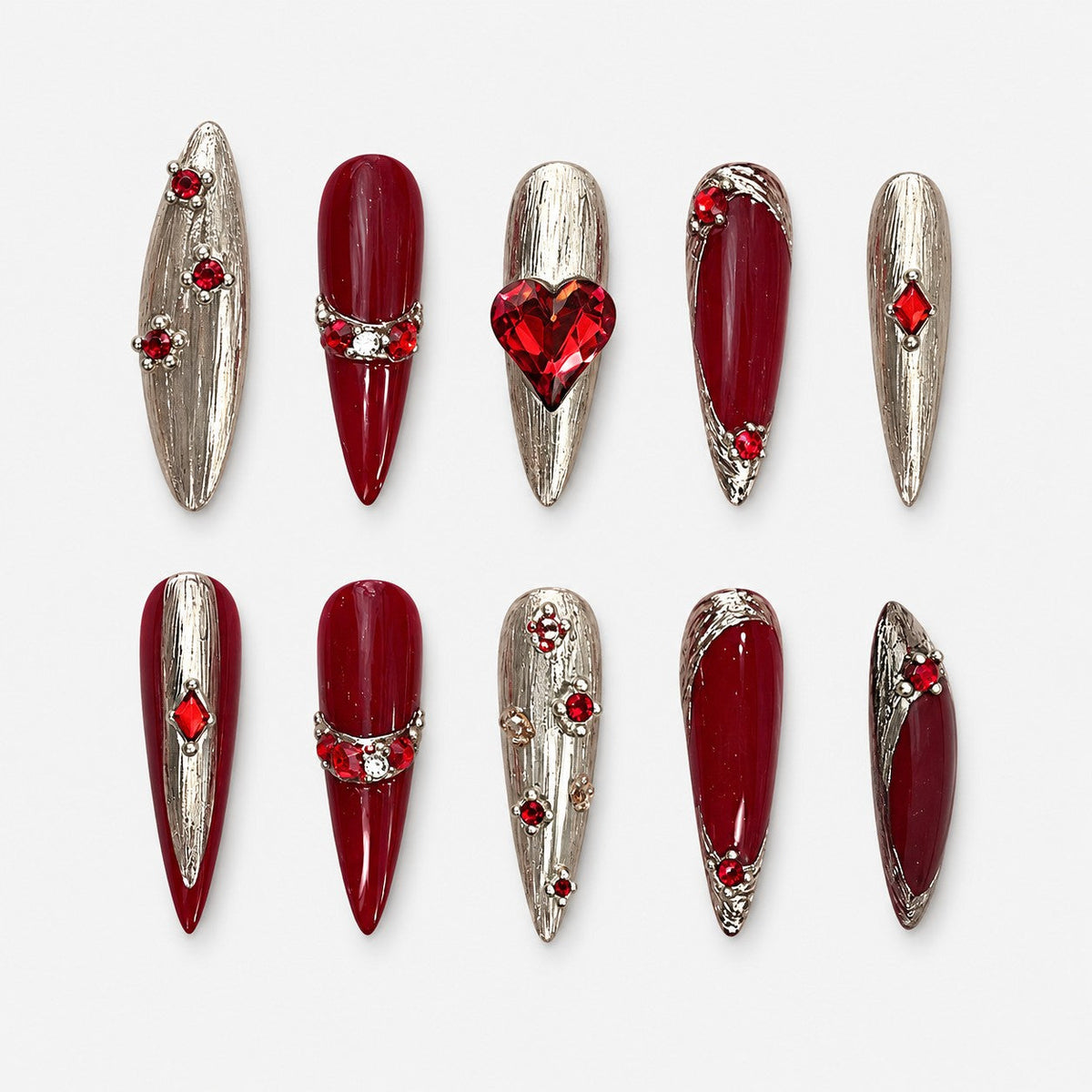 catalog: Long stiletto nails in deep red and brushed silver with a faceted red heart stone and scattered red crystals.