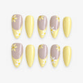 catalog: Long almond press-on nails with a pale yellow French tip over a greige base and small hand painted white and yellow daisies.