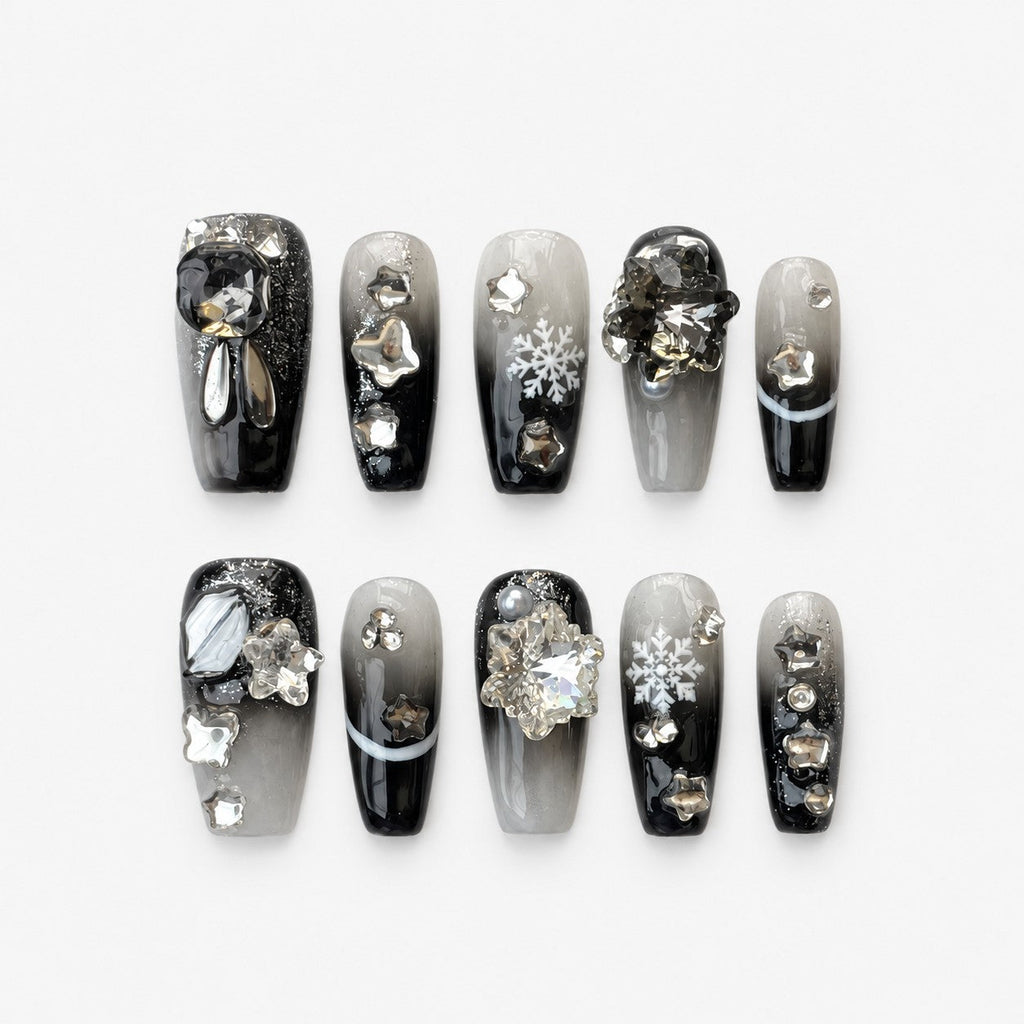 catalog: Coffin shaped press-on nails with black and grey gradient, silver glitter, crystal snowflake charms and mirrored star studs.