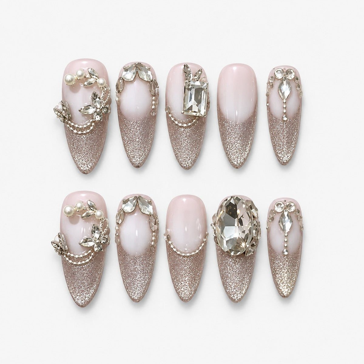 catalog: Long almond press-on nails with milky pink bases, silver cat-eye shimmer, clear faceted crystals, sculpted leaf vines and small pearls.