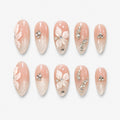 catalog: Almond medium press-on nails in milky nude with pearl shimmer, sculpted white 3D flowers and clear rhinestone accents.