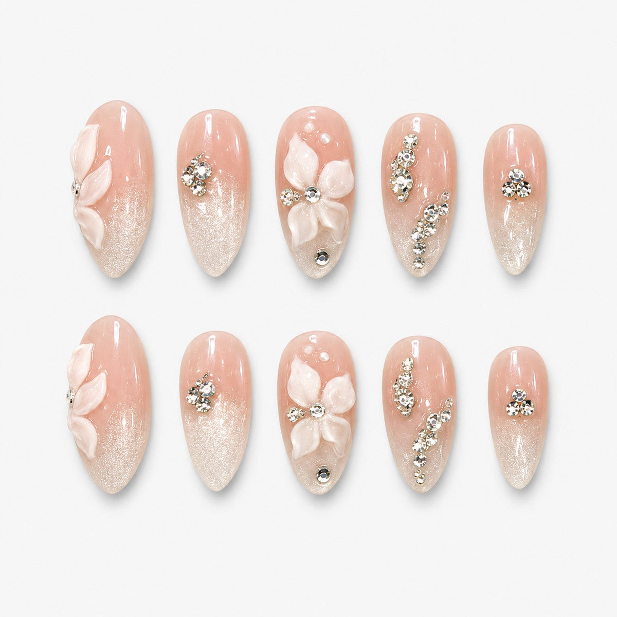 catalog: Almond medium press-on nails in milky nude with pearl shimmer, sculpted white 3D flowers and clear rhinestone accents.