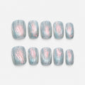 catalog: Short square press-on nails in frosted ice blue with textured ripples, a pearly pink shimmer through the centre and silver glitter lines.