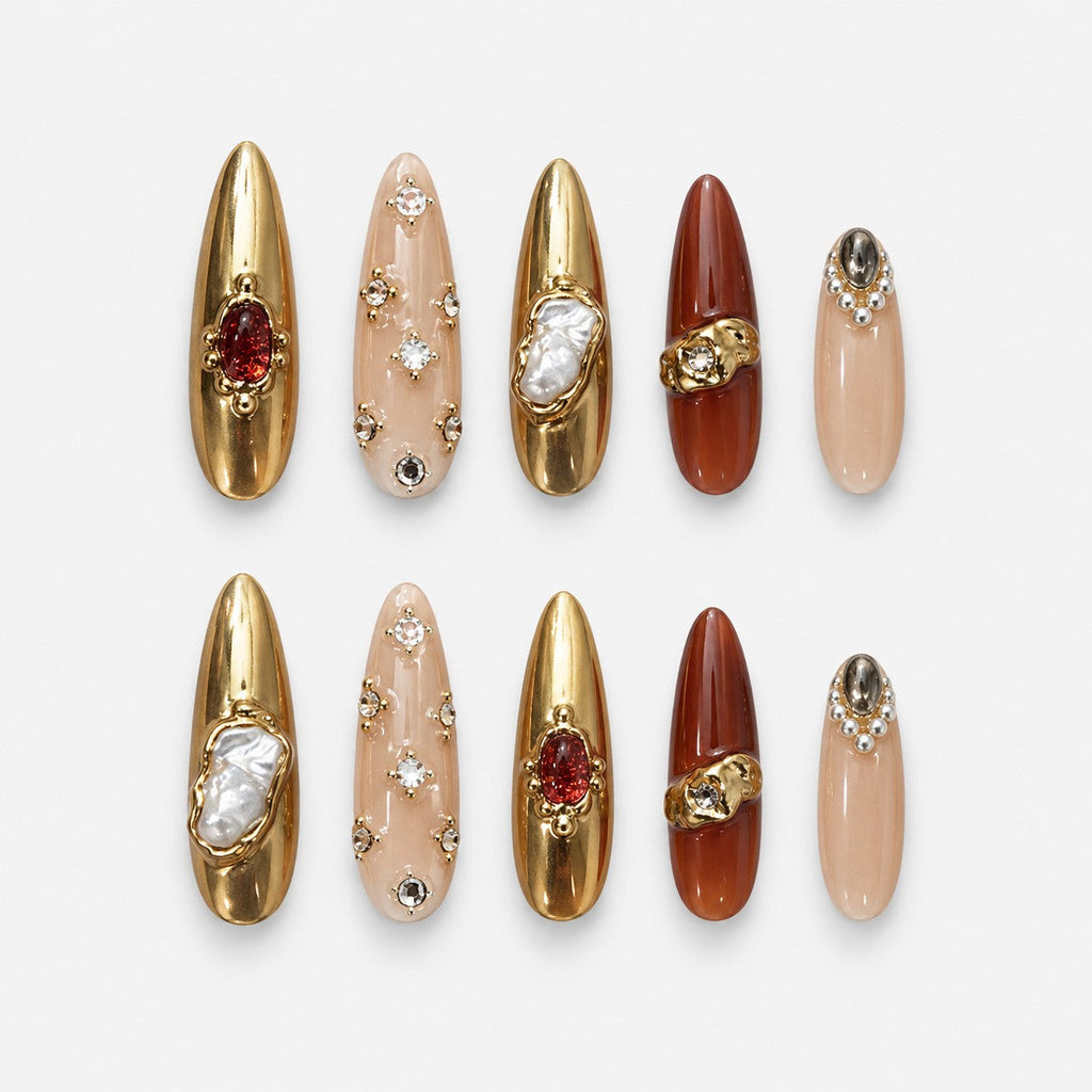 catalog: Long almond press-on nails in gold chrome and amber brown with baroque pearls, crystals and raised gold sculpting.