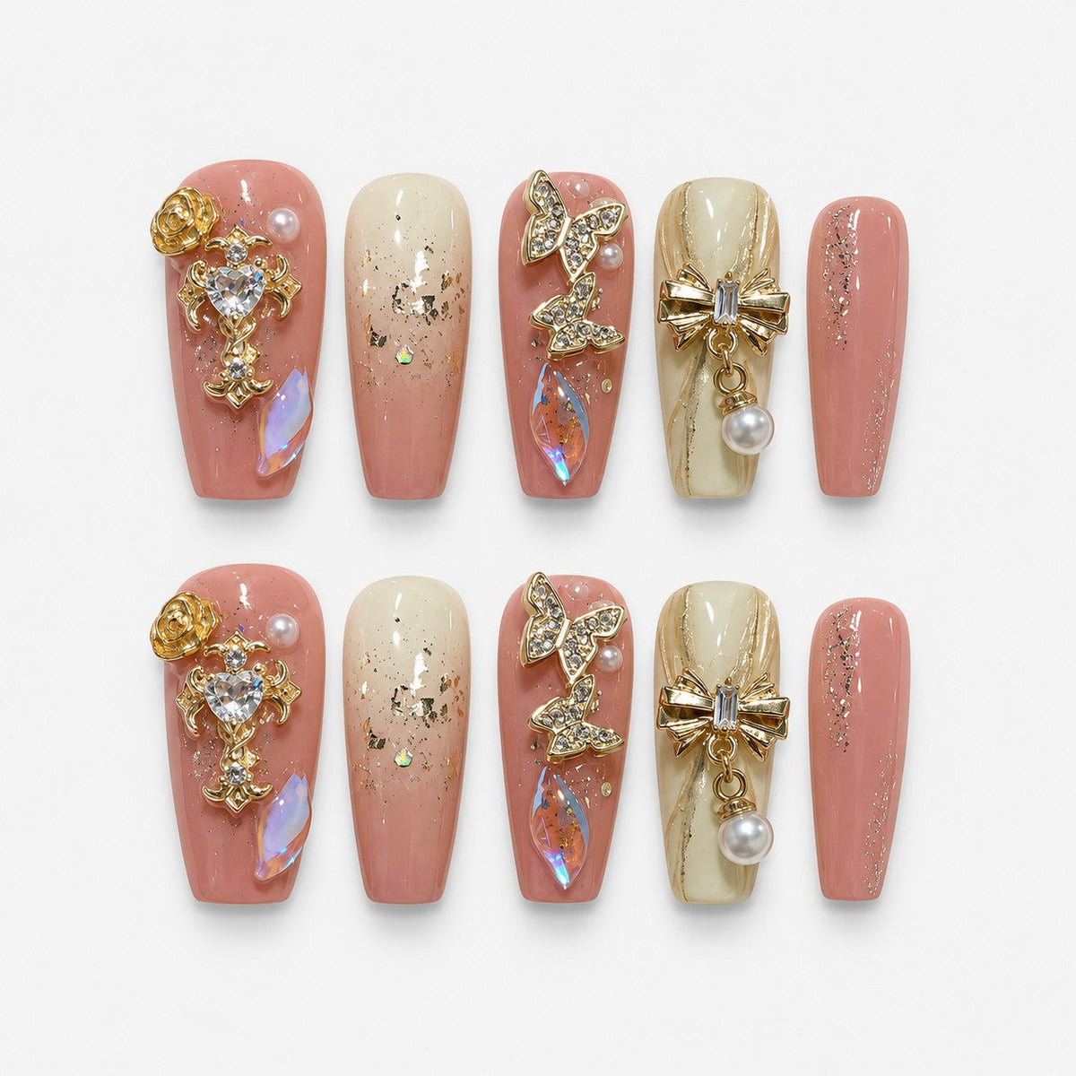catalog: Long coffin press-on nails in pink and ivory with gold leaf, rhinestone butterflies, a gold bow with a pearl drop and a crystal heart charm.