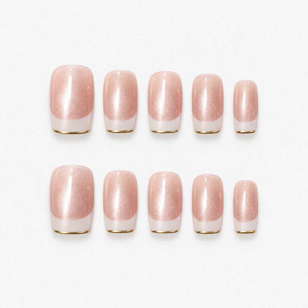 catalog: Medium square-ish press-on set in warm nude with a cat-eye shimmer stripe, white French tips and thin gold edging.