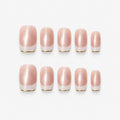 catalog: Medium square-ish press-on set in warm nude with a cat-eye shimmer stripe, white French tips and thin gold edging.