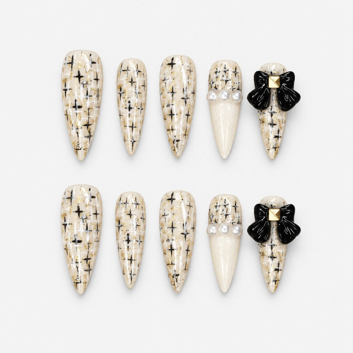 catalog: Long ivory stiletto nails with painted black and gold tweed, glossy black bows with gold studs and small pearls.