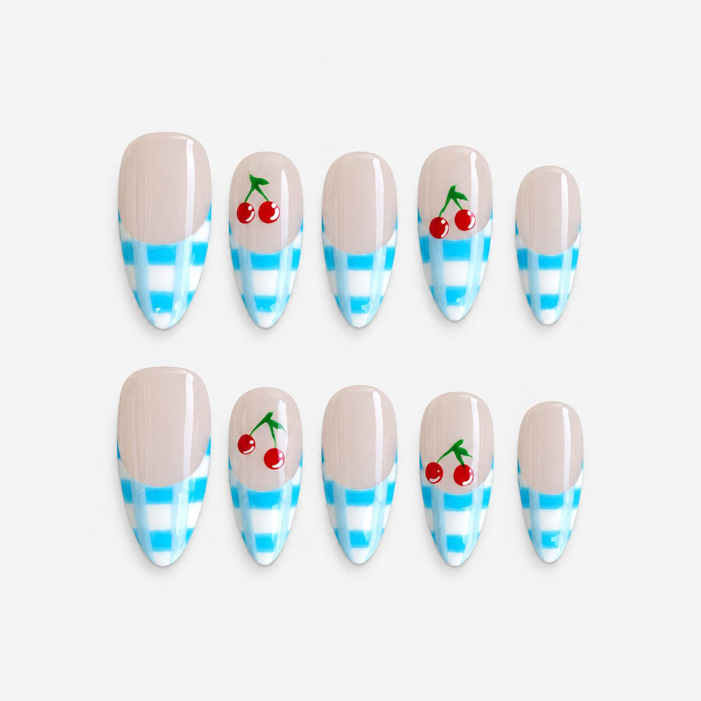 catalog: Almond nails with nude base, blue and white gingham French tips and painted red cherries on two accent nails.