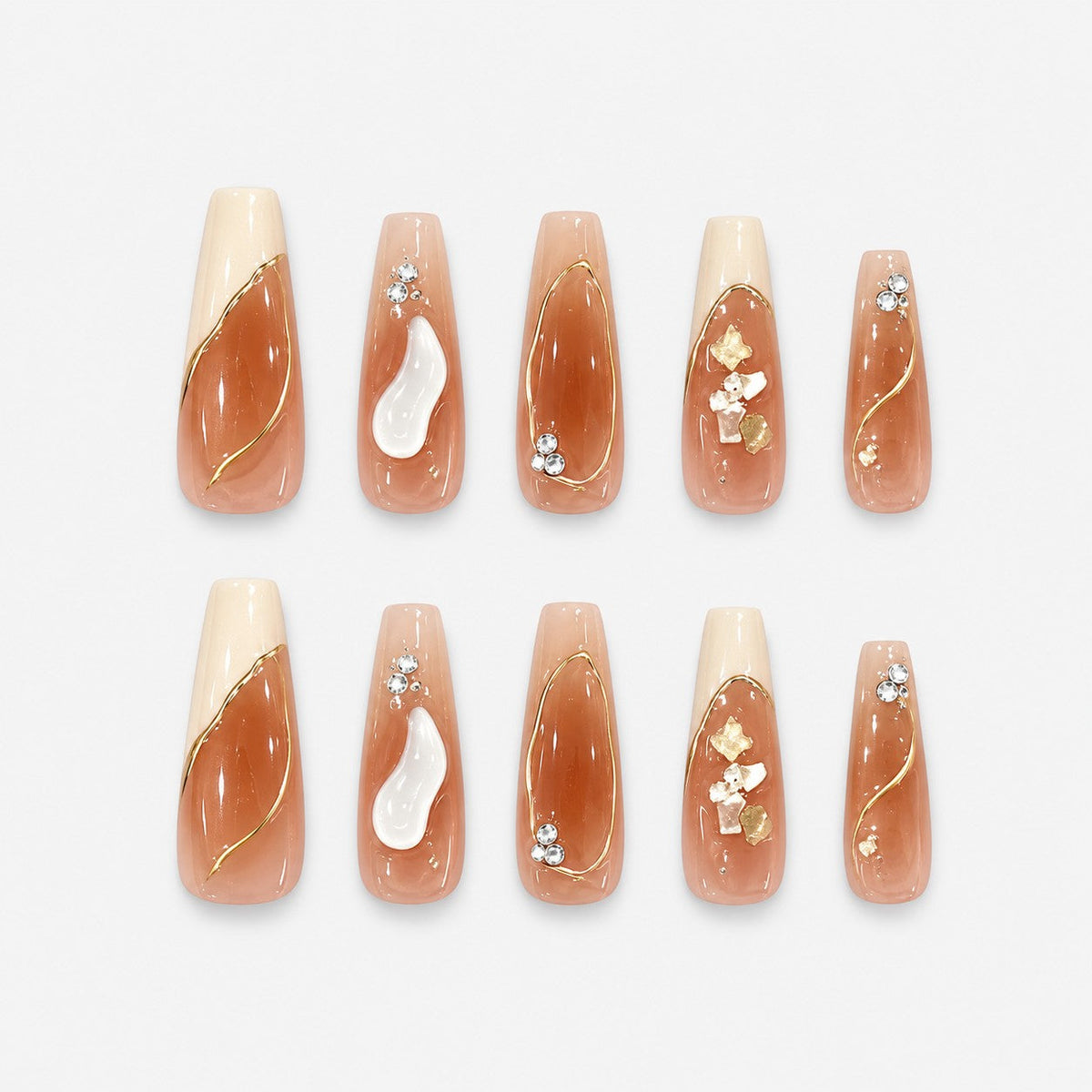 catalog: Long coffin nails in sheer nude with gold foil outlines, small white flowers, cream tips and tiny crystals.