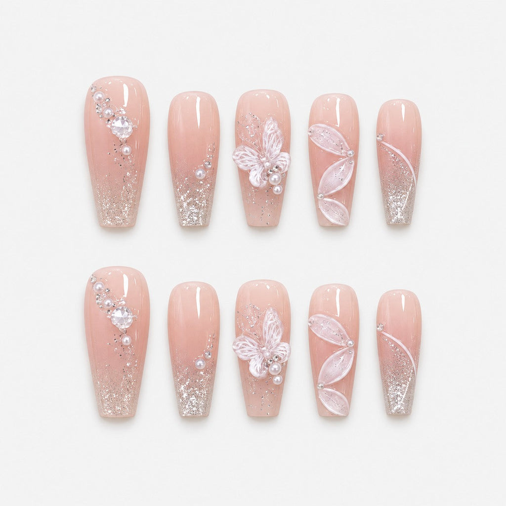 catalog: Long coffin press-on nails in sheer nude pink with silver shimmer, a sculpted white butterfly, sheer petal wings and small pearls.