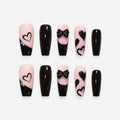 catalog: Long coffin press-on nails in near black over soft pink with slanted French tips, painted hearts and a sculpted black bow.