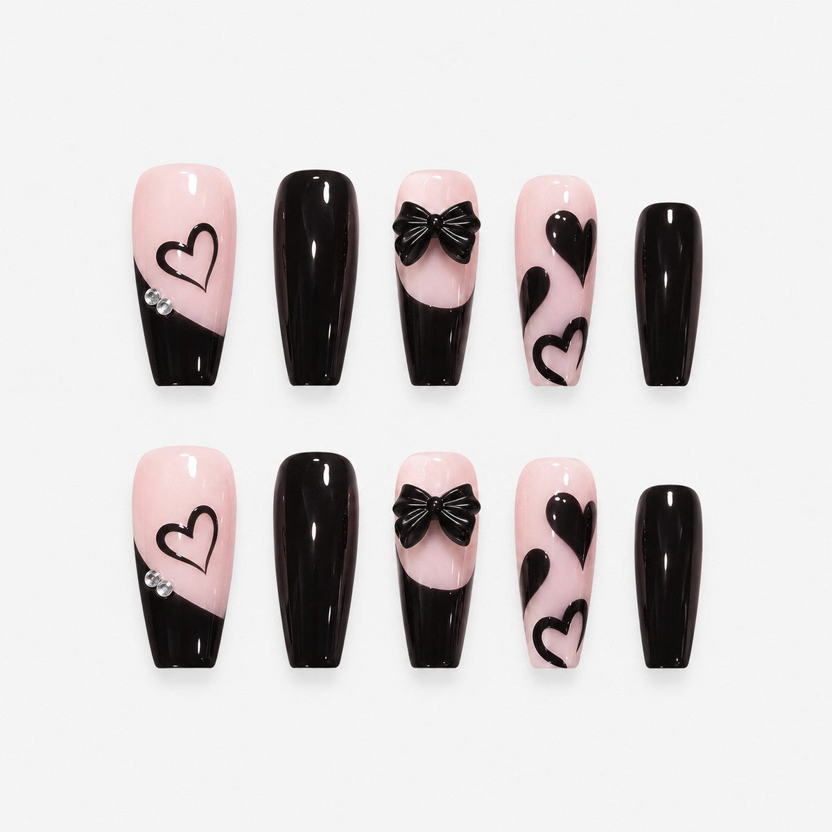 catalog: Long coffin press-on nails in near black over soft pink with slanted French tips, painted hearts and a sculpted black bow.