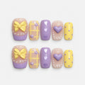 catalog: Short square press-on nails in lilac and pastel yellow with a sculpted bow, a raised heart, painted hearts, grid lines and white dot borders.