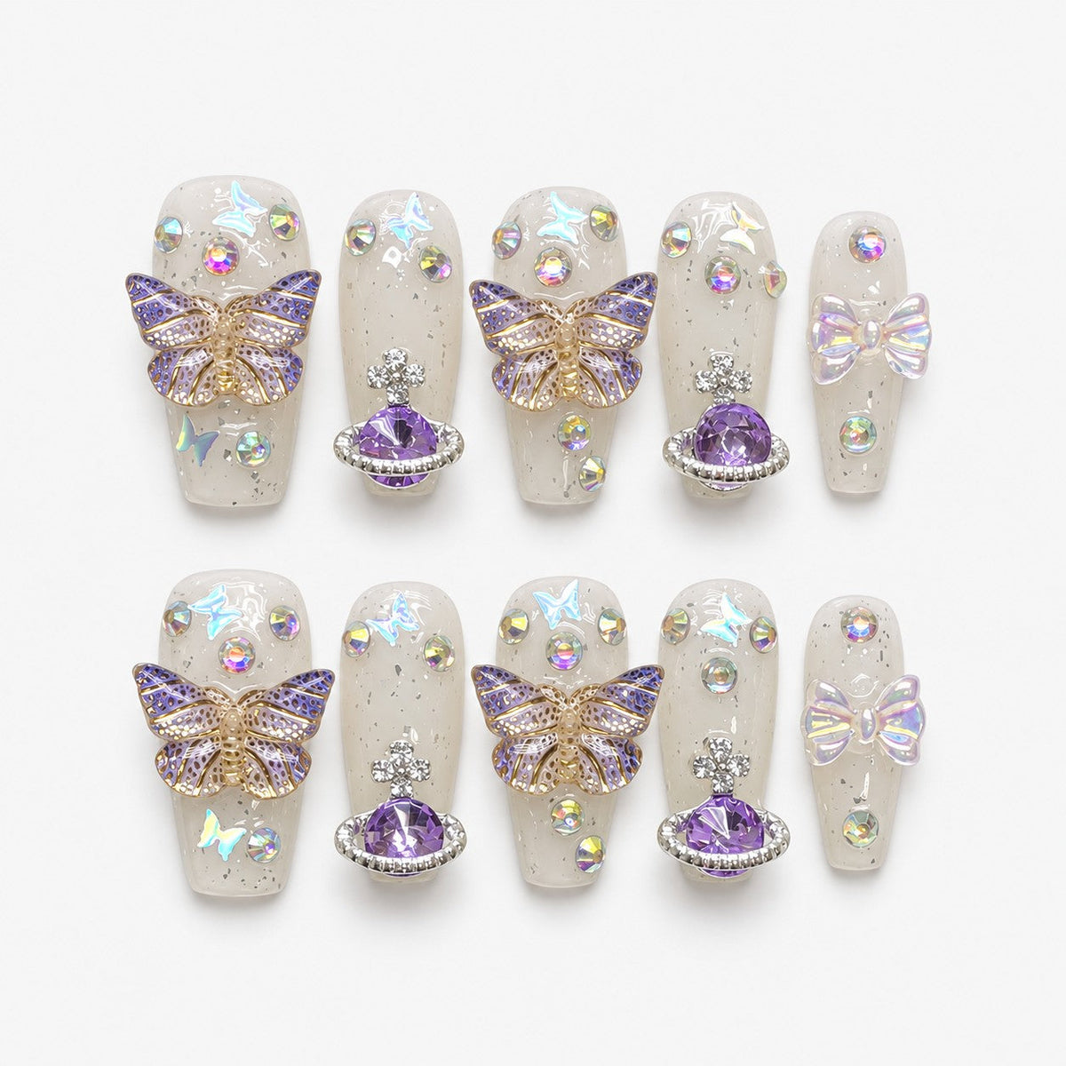 catalog: Medium coffin press-on nails in milky translucent white with purple 3D butterflies, a faceted purple planet charm, an iridescent bow and aurora rhinestones.