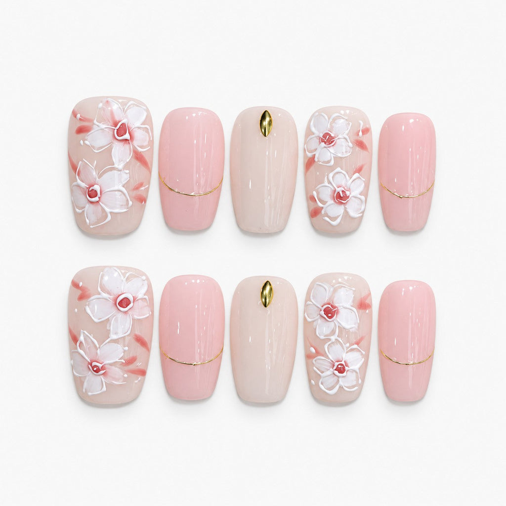 catalog: Medium square press-on set in milky pink with raised white magnolia flowers, coral brushstrokes and thin gold lines.