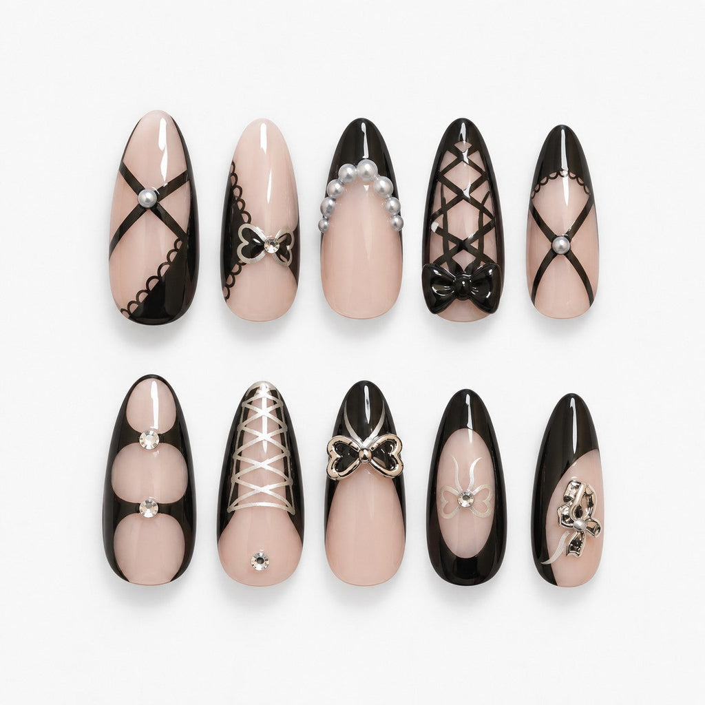 catalog: Long almond nails with sheer nude bases, black French tips, painted black lace lines, grey pearls and raised glossy black bows.