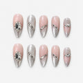 catalog: Medium almond press-on nails in nude with pearly silver cat-eye shimmer, crystal accents along the edges and two large faceted stones.