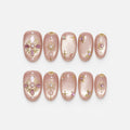 catalog: Medium almond press-on nails in shimmering pearly nude with gold star linework, pearls and a lilac gemstone flower.