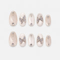 catalog: Almond medium press-on nails in pearly white cat-eye velvet with crystal butterfly charms and small rhinestone lines.