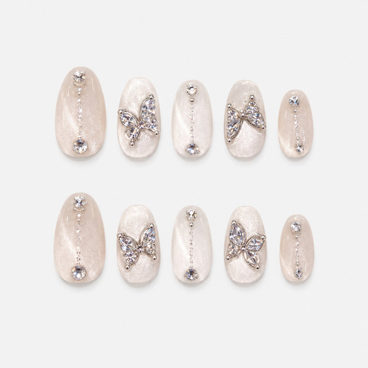 catalog: Almond medium press-on nails in pearly white cat-eye velvet with crystal butterfly charms and small rhinestone lines.