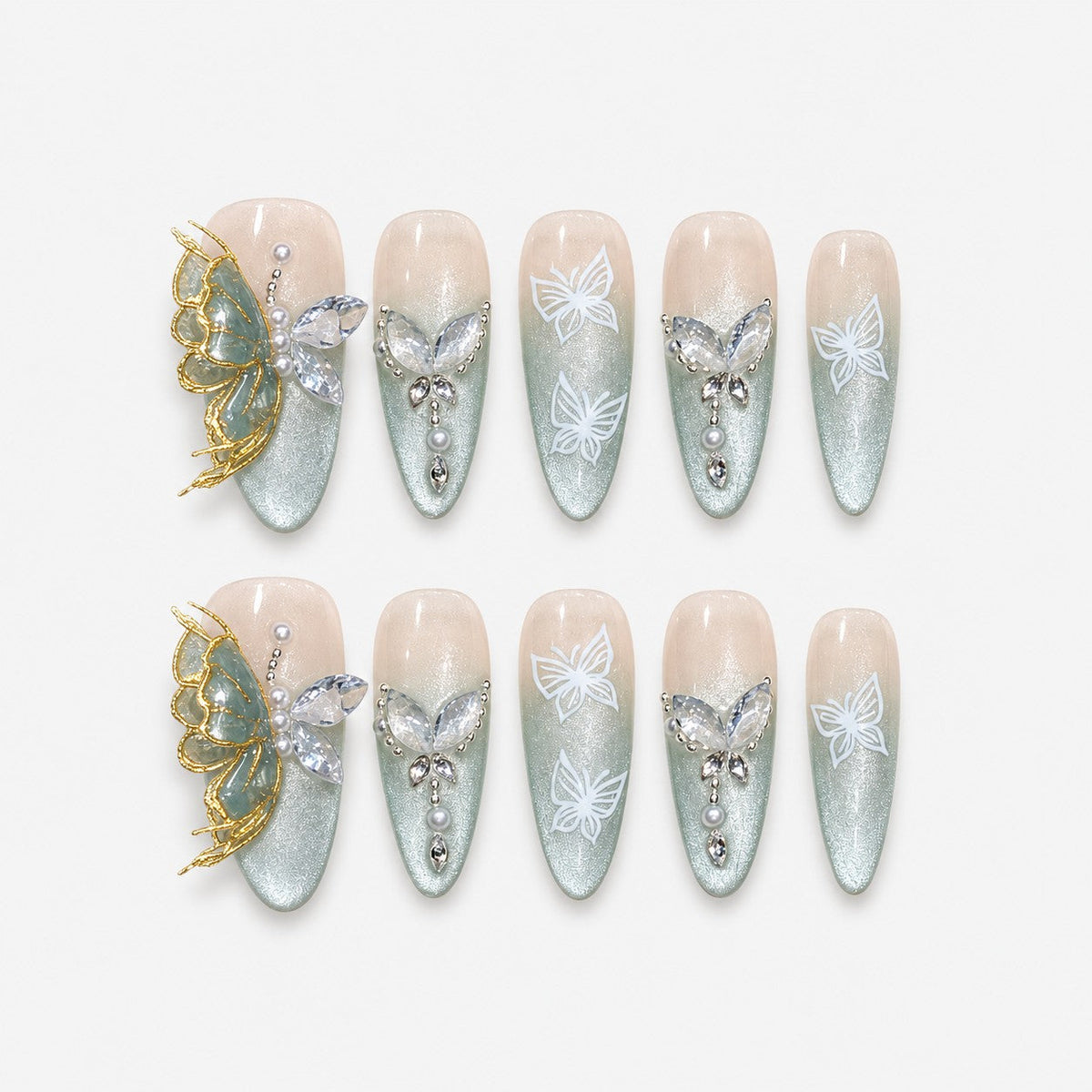 catalog: Long almond press-on nails with nude to sage green cat-eye gradient, white painted butterflies, crystals, pearls and a raised gold and stone butterfly charm.