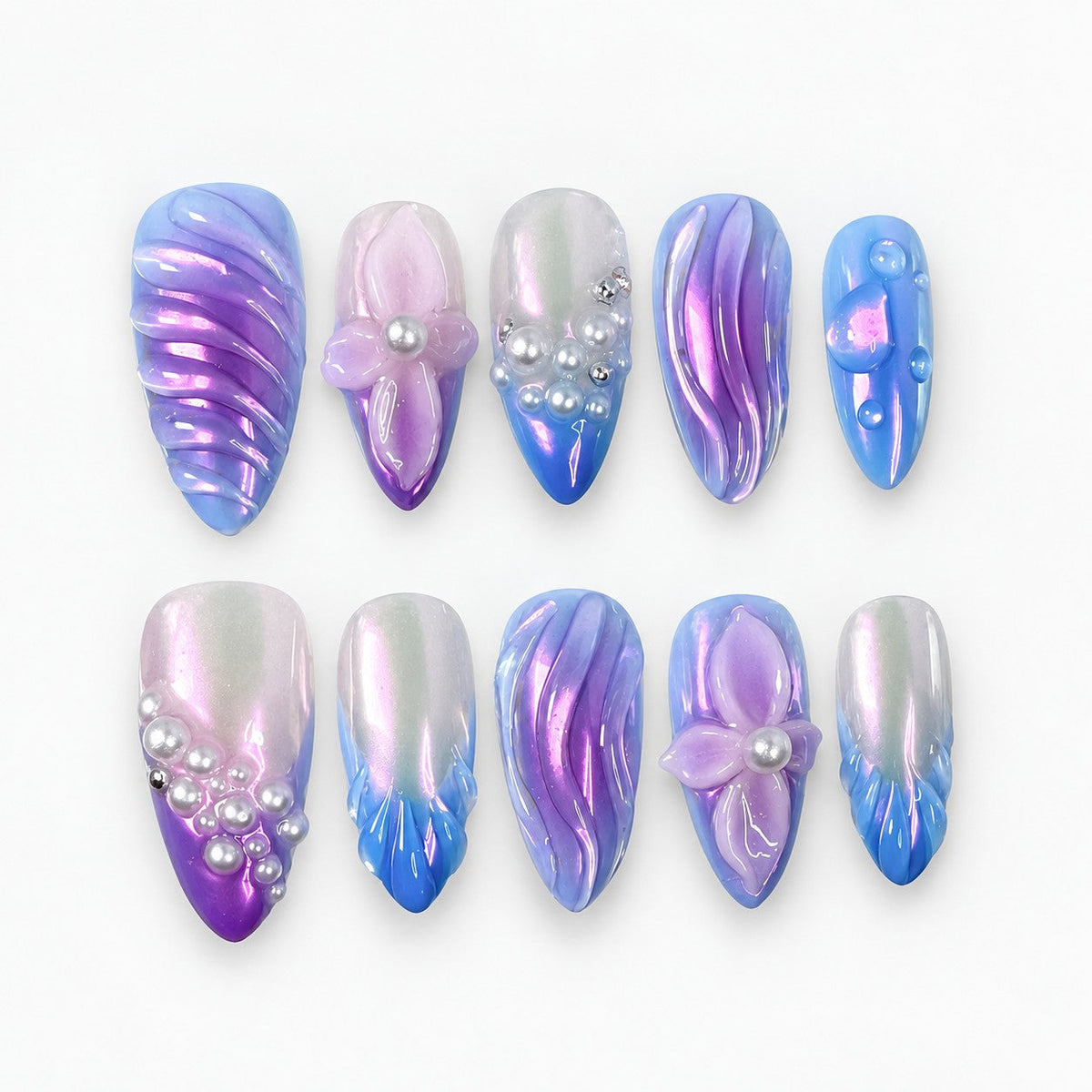 catalog: Long almond press-on nails in lilac, violet and blue chrome with sculpted ripples, raised flowers with pearl centres and clustered pearl accents.