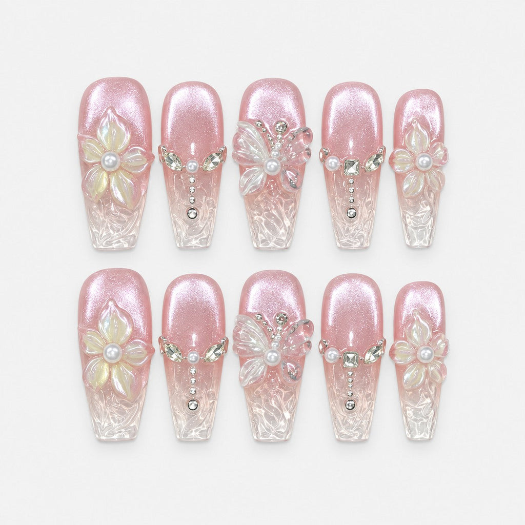 catalog: Long coffin press-on nails in pearly pink cat-eye fading to clear tips, with raised white 3D flowers and butterflies, pearls and crystal chain details.