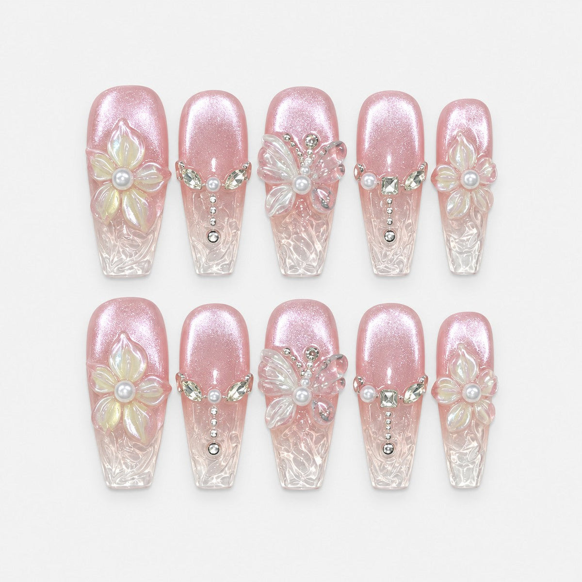 catalog: Long coffin press-on nails in pearly pink cat-eye fading to clear tips, with raised white 3D flowers and butterflies, pearls and crystal chain details.