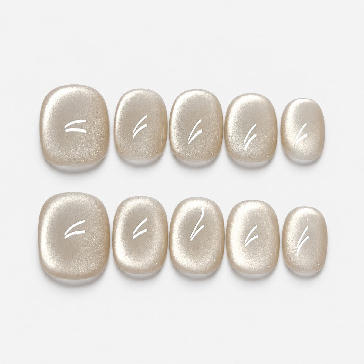 catalog: Short rounded press-on nails in a creamy champagne pearl shade with a soft cat eye shimmer band across each nail.