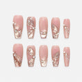 catalog: Long pink sheer nails with sculpted glitter petals, small pearls and rhinestones over a shimmering base.