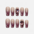catalog: Medium coffin-shaped press-on nails with a nude to plum cat-eye gradient and a large pink faceted crystal on one nail.