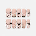 catalog: Medium square press-on nails in sheer blush pink with thin black French tips, black dots, raised black bows and pearl flower clusters.