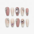 catalog: Long coffin press-on nails in dusty pink and milky cream with clusters of clear crystals and large faceted pink oval and heart gemstones.