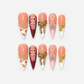 catalog: Long stiletto press-on nails in peach and dark red with white tips, raised gold and silver bows, painted roses, gold beads and pearls.
