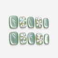 catalog: Short square press-on nails in sage green cat-eye finish with raised white sculpted flowers and iridescent glitter flecks.