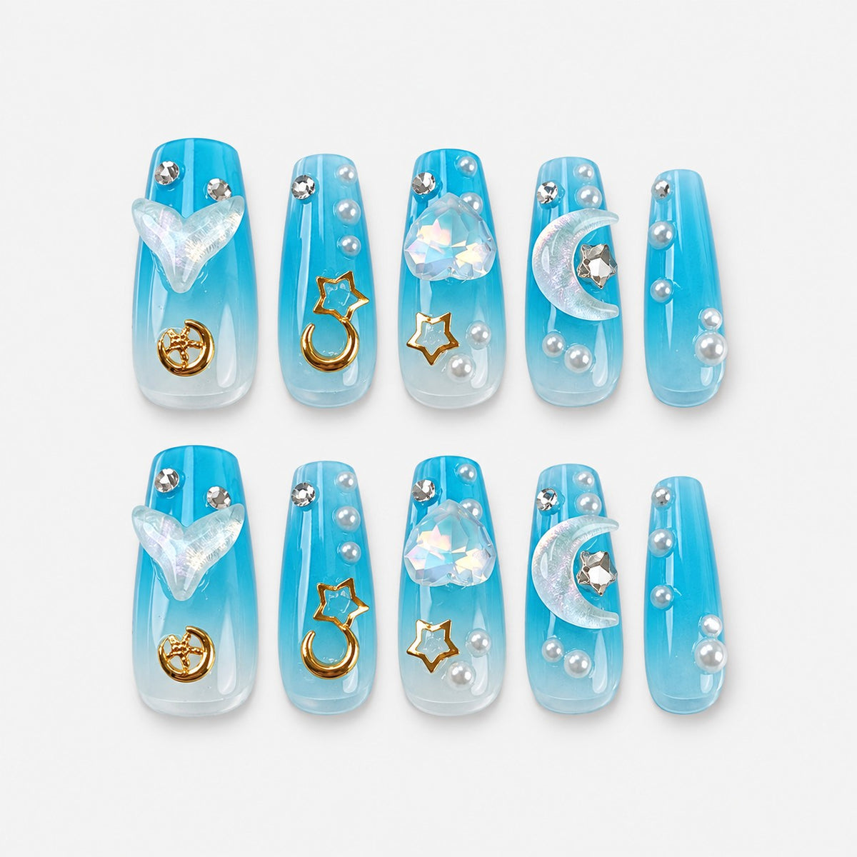 catalog: Long coffin press-on nails in ocean blue fading to white, with sculpted mermaid tails, gold moon and star charms, crystals and pearls.