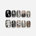 catalog: Short square press-on nails in grey, taupe and black with silver chrome, pearls, metal beads and hand-painted line art, displayed in a wooden box.