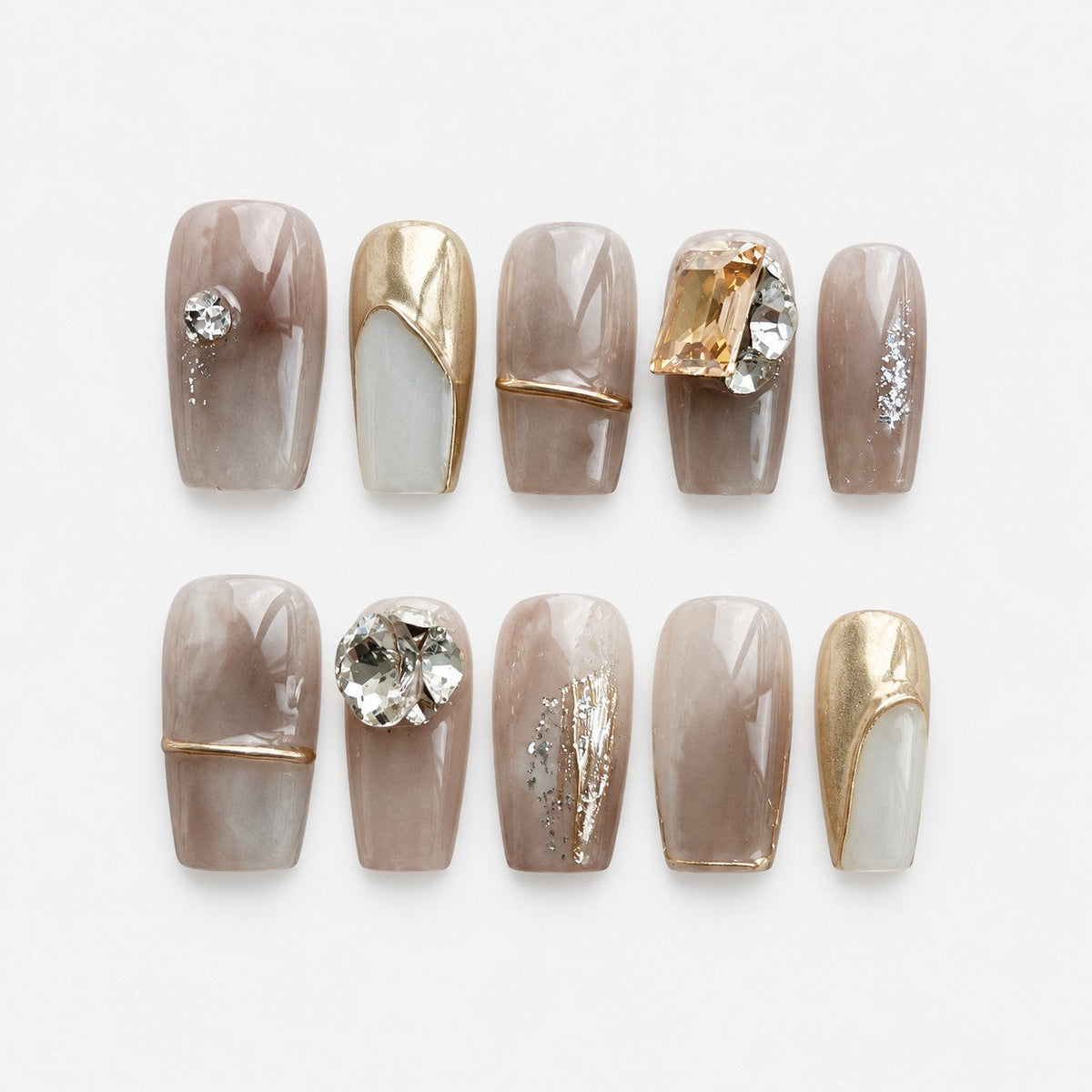 catalog: Medium square press-on nails in smoky taupe marble with gold outlines, a mirrored gold nail, silver foil detail and large clear and champagne crystals.